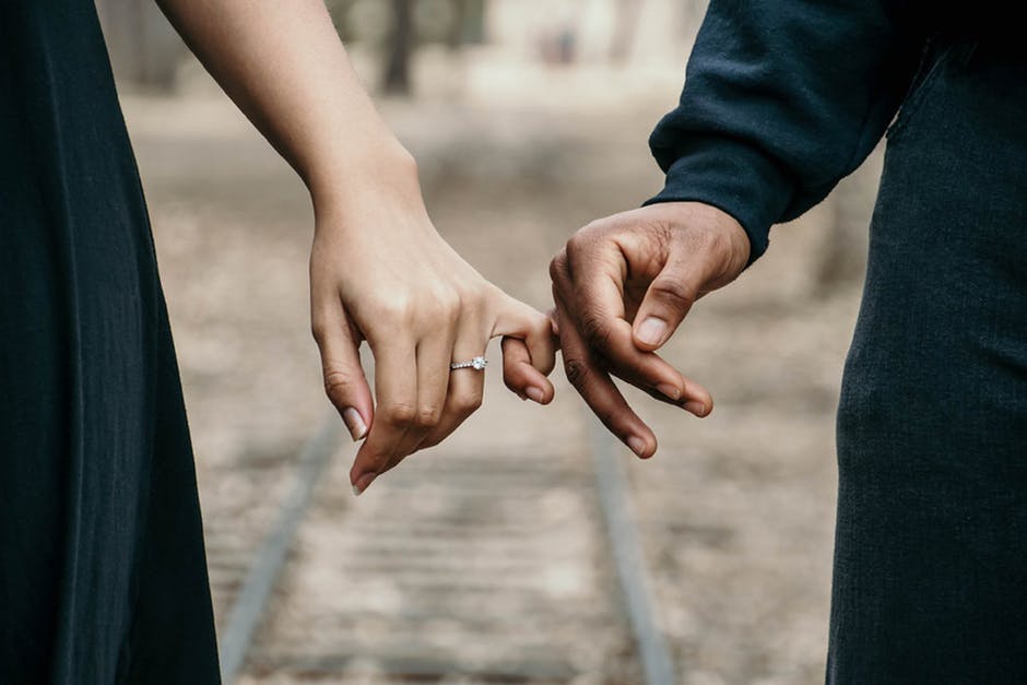 couple holding hands with ring